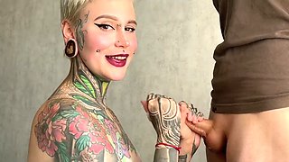 Tattooed bitch is jacking off the guy's cock with some nice tempo