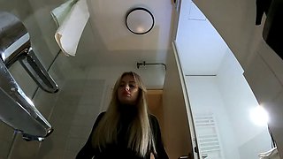 Big Tits Big Ass Hot Blonde Babe in Pantyhose and High Heels with a Miniskirt does a Striptease in the Bathroom