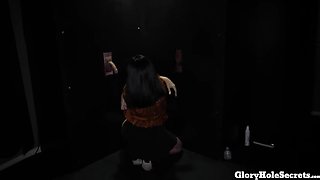 Brunette girl enjoys playing with a BBC through glory hole