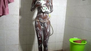 Ebony babe soaps up under the spray then takes it against the tiles