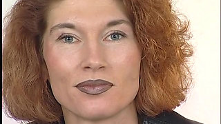Tattooed ginger milf is filling her pussy with a big dildo