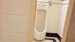 Femboy about to caught while exposure in public men's toilet with metal chastity cage and microskirt on.