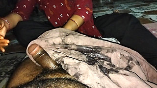 A desi wife massaging her husband's member with oil using her soft hands at night.