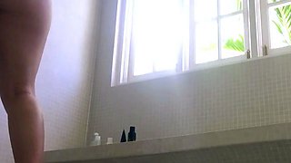 A bare adult damsel sits in a bathroom to jerk using