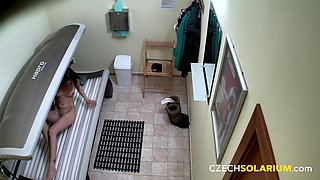Czech Solarium 40: Brunette Flashes Her Pussy with a Naughty Smile
